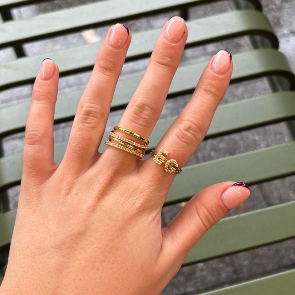 Hand with gold rings on a green metal bench